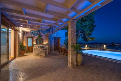 an outdoor patio with a swimming pool at night at Castelli by Vintage Travel in Lagópodhon