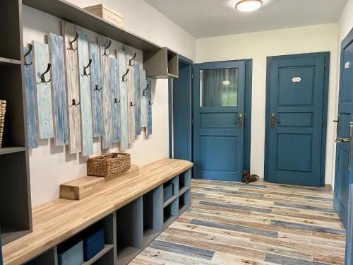 a hallway with blue doors and a wooden bench at Chata Tanvaldka in Tanvald