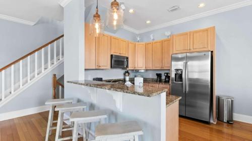 a kitchen with a stainless steel refrigerator and wooden cabinets at Three Herons Roost by Emerald Coast Retreats in Sunnyside