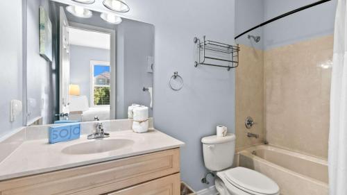a bathroom with a sink and a toilet and a tub at Three Herons Roost by Emerald Coast Retreats in Sunnyside