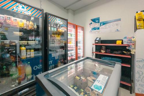 a store with a refrigerator and a counter with food at Seu apê ideal te espera! CA1306 in Maringá