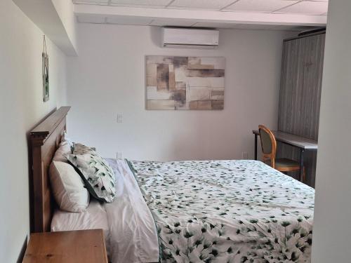 a bedroom with a bed and a chair in it at Hostellerie du Suroît in Beauharnois