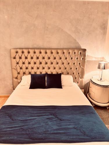 a bedroom with a large bed with a large headboard at Logis Hôtel Saint Martin in Orléans