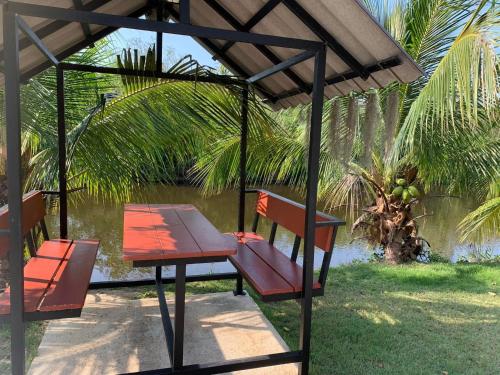 a picnic table and bench under a gazebo at Ban Rim Nam Klongwan in Klong Wan