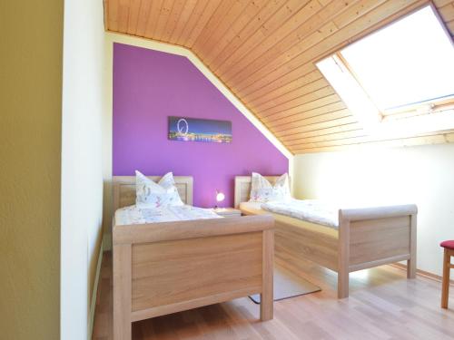 two beds in a room with purple walls at Lirstal Family Getaway in Lirstal