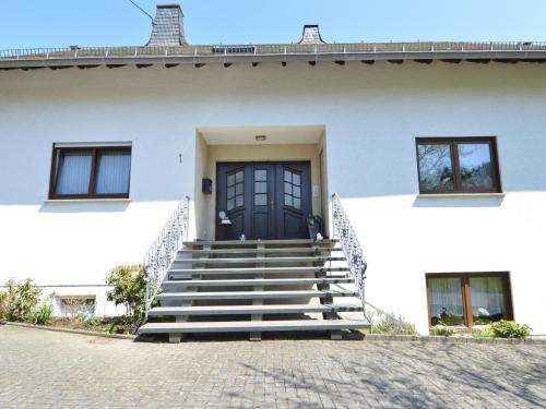 a white house with a black door and stairs at Lirstal Family Getaway in Lirstal