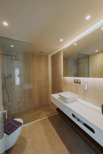 a bathroom with a tub and a sink and a shower at Volaka Luxury Suites in Kos Town