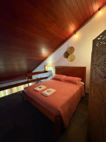 a bedroom with a bed with two towels on it at Loft charmoso bem no centro in São Sebastião