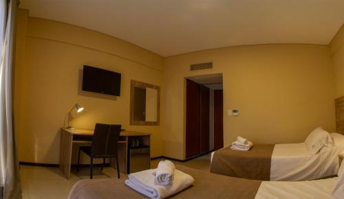 a hotel room with two beds and a desk at Hotel Telepostal Congreso in Buenos Aires