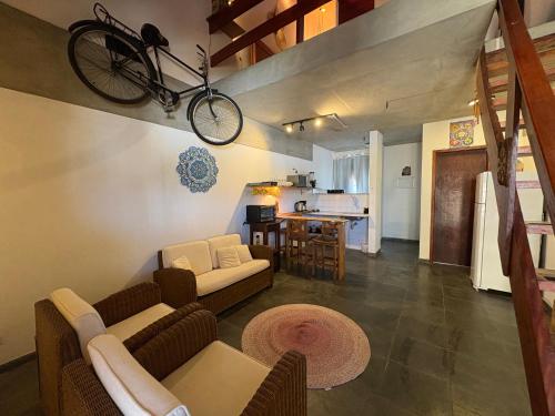 una sala de estar con una bicicleta colgada del techo en Loft charmoso bem no centro, en São Sebastião