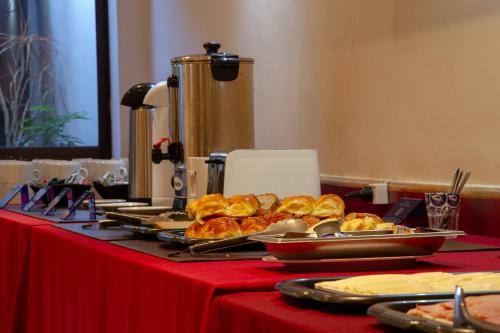 a table with plates of food on a red table at Hotel Telepostal Congreso in Buenos Aires