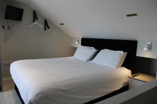 Un dormitorio con una cama grande con sábanas blancas. en MOXIE LUXURY APARTMENTS, en Belfast