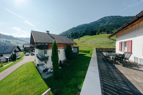 a view of a house with a patio and a yard at Ferienwohnung Wallis in Raggal