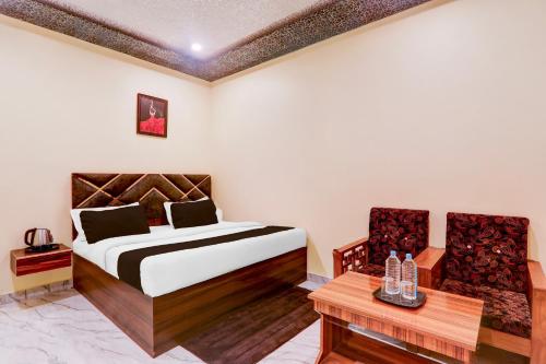 a bedroom with a bed and a table and chairs at Super Hotel O Blue Heaven in Gorakhpur