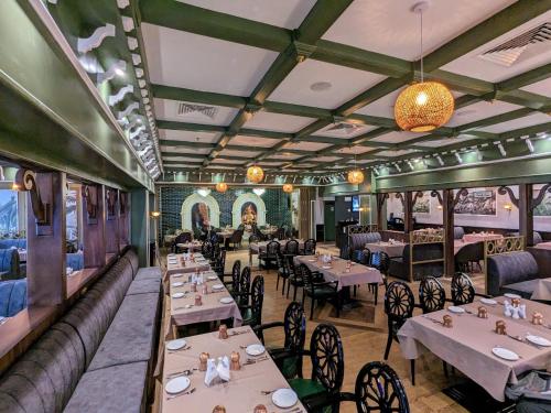 a restaurant with tables and chairs and a train at Dubai Grand Hotel by Fortune, Dubai Airport in Dubai