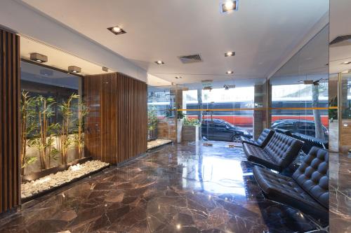 a lobby with two black leather chairs in a building at Hotel Telepostal Congreso in Buenos Aires
