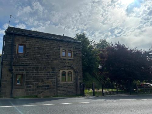 a brick building on the side of a street at The Barn, Holden gate Farm Todmorden in Todmorden
