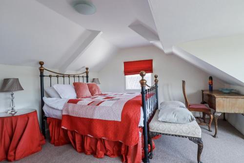 a bedroom with a bed with a red and white blanket at Kiln Cottage in Fowey
