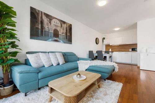 a living room with a blue couch and a table at Urban Elegance Retreat in Bratislava