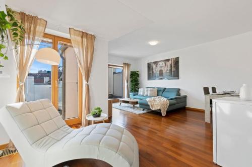 a living room with a white chair and a couch at Urban Elegance Retreat in Bratislava