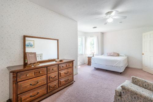 a bedroom with a dresser with a mirror and a bed at Country Cottage in Apple Creek