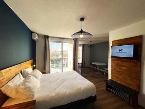 a hotel room with a bed and a television at Les appartements du Clos de la Chartreuse By Ateya in Aix-en-Provence
