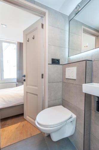 a bathroom with a toilet and a sink and a bed at Holiday Home in Antwerp in Antwerp