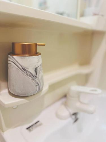 a container sitting on a shelf next to a sink at Shinjuku city西新宿 in Tokyo