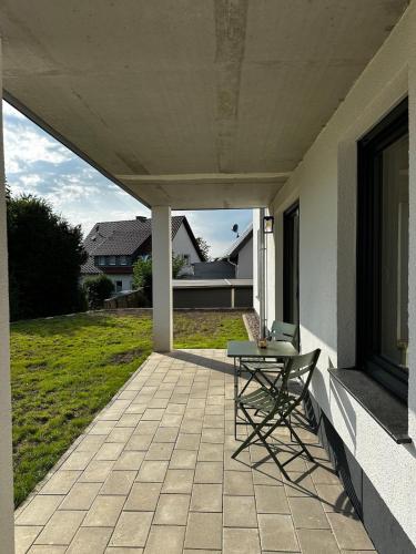 a patio with a table and a chair on a house at Ferienwohnung an der Windmühle in Horn-Bad Meinberg