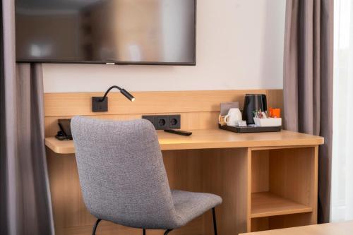 a desk with a chair in a hotel room at Best Western Plus Hotel Papenburg in Papenburg