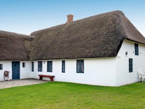 a thatched roof house with a bench in the yard at Charming Retreat on Mando - By Traum Ferienwohnungen in Mandø By