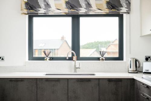 une cuisine avec un évier et une fenêtre dans l'établissement Jurassic BR26 Silverlake Dorset, à Warmwell