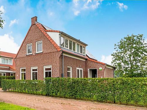 a red brick house with a hedge in front of it at Breskens Haven Relax, Explore & Dine in Breskens