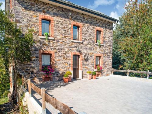 a stone house with potted plants in front of it at Holiday Home in Lierneux with Garden in Lierneux