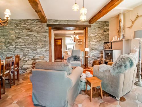 a living room with couches and a stone wall at Holiday Home in Lierneux with Garden in Lierneux