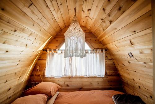 a bedroom in a log cabin with a chandelier at Cozy Glamping Pod for a Nature Escape in Monticello, Utah in Monticello