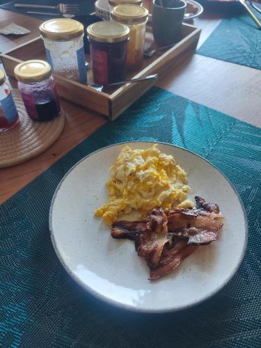 a plate of breakfast food with bacon and eggs at Manoir des 2 Sources in Monestier