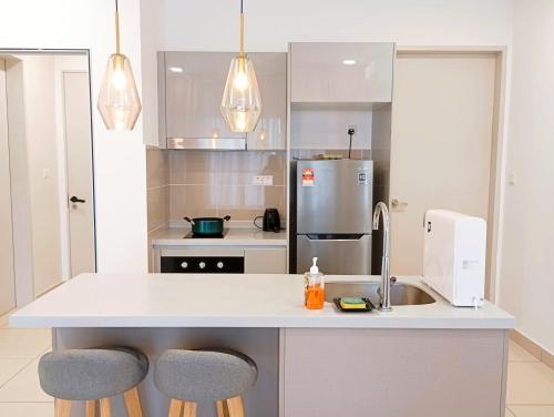 cocina con fregadero y 2 taburetes en Trion Kuala Lumpur Near by TRX, en Kuala Lumpur