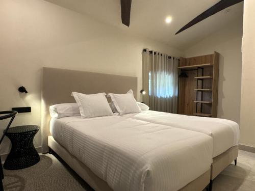a bedroom with a large bed with white sheets at Hotel El Paraíso del Pas in Barcenilla