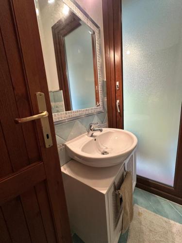 une salle de bain avec un lavabo et un miroir dans l'établissement Casa Vacanze Margherita, à Stintino