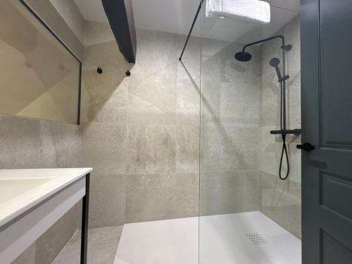 a bathroom with a shower with a glass door at Hotel El Paraíso del Pas in Barcenilla