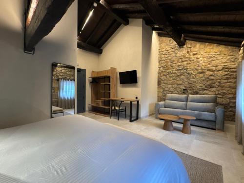 a bedroom with a bed and a couch and a tv at Hotel El Paraíso del Pas in Barcenilla
