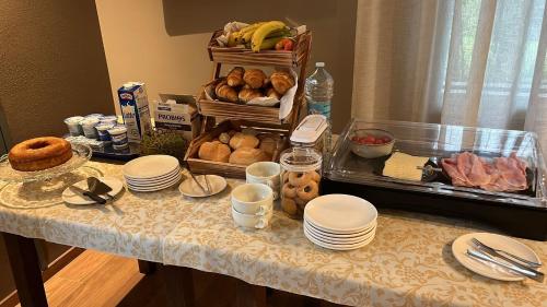 a table with plates and food on top of it at Tosa Welcome in Imola
