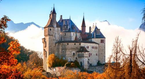 a castle on top of a hill with trees at Saint-Jorioz, charmante maisonnette indépendante. in Saint-Jorioz