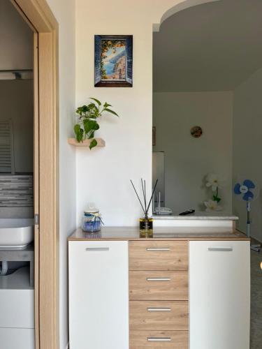a kitchen with white cabinets and a sink at Nello House in Vico Equense