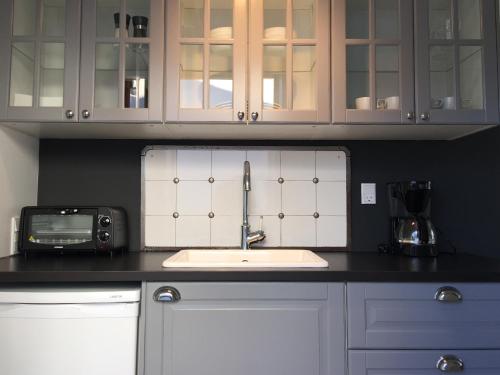 a kitchen counter with a sink and a microwave at Dragondrum Bed & Kitchen in Ullerslev
