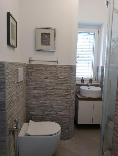 a bathroom with a toilet and a sink at Domus 190 rooms in Varese