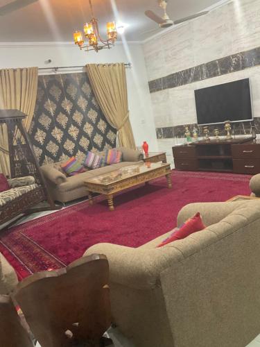 a living room with two couches and a tv at sheen house in Rawalpindi