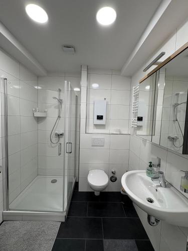 a bathroom with a shower and a toilet and a sink at RUEHOME in Essen