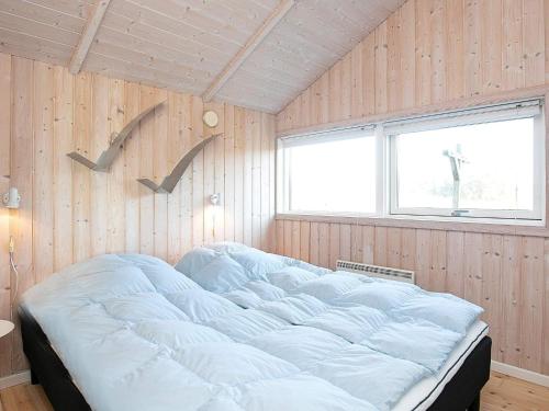 a bedroom with a large bed in a wooden wall at Tranquil Retreat in Klitmoller - By Traum Ferienwohnungen in Klitmøller